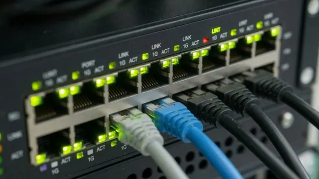 Close-up of a network switch with patch cables and green status lights